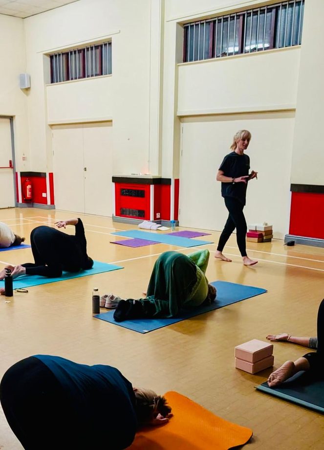 The main hall at Oakwood Church, with students resting on mats and Jenny walking between them